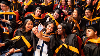 students take a selfie at graduation