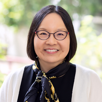 A headshot of Alison Huang - she is wearing glasses, is smiling, has chin length black hair, a black shirt and tan cardigan.