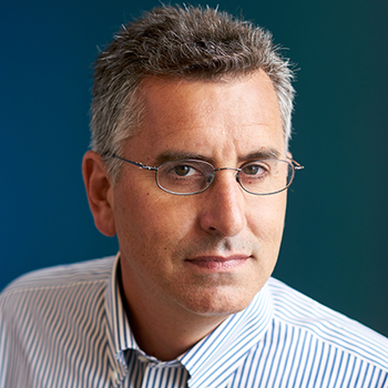 A professional headshot of Adam