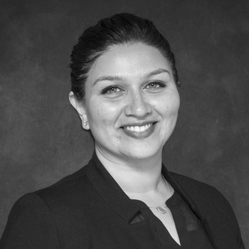 A black and white professional head shot of Meghana