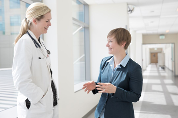 Doctor and faculty talking in a hallway